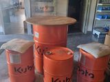 Plusieurs fûts orange sont empilés les uns sur les autres dans un garage