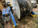 a large cable spool sitting on the ground next to a pile of junk