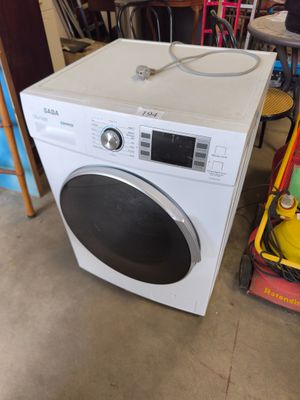 une machine à laver posée à côté d'une pile d'autres appareils électroménagers