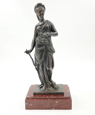 a bronze statue of a woman holding a staff on a marble base