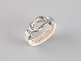 a close up of a silver ring with a knot on it