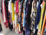 a lot of clothes hanging on a rack in a store