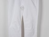 un pantalon blanc suspendu à un cintre devant un mur blanc