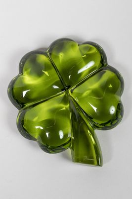 broche en verre vert en forme de trèfle à quatre feuilles sur un fond blanc