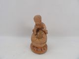 a small figurine of a boy sitting on top of a bowl