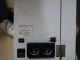 a person holding a microwave that is sitting on the floor