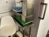 a picture of a small kitchen with a refrigerator and a chair