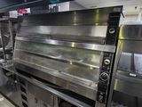 des fours en acier inoxydable dans une cuisine professionnelle disposant d'un grand plan de travail