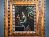 a painting of a woman reading a book in a wooden frame
