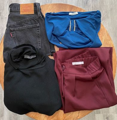 trois paires de pantalons pour homme posées sur une table en bois