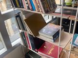 a book shelf with books on it in front of a window