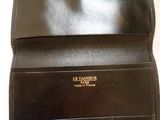 a close up of a black leather wallet on a white surface