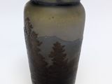 a brown vase with trees on it on a white surface