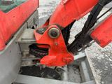 a red excavator that is sitting on the ground