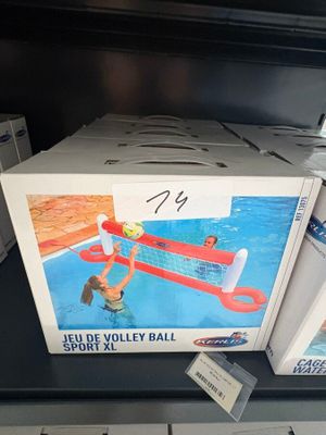 une boîte de ballons de volley-ball posée sur une étagère dans un magasin