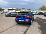 a blue car parked in a parking lot next to other cars