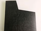 a close up of a piece of black paper on a white surface