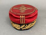 a red hat with a gold decoration on it