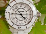 a white watch sitting on top of a white table