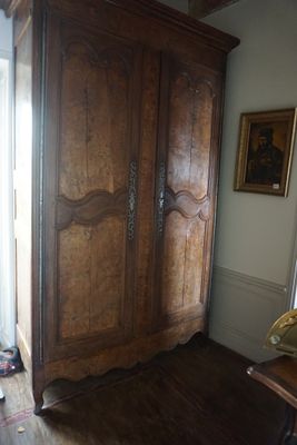 une grande armoire en bois dans le coin d'une pièce