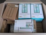 de nombreuses boîtes contenant des appareils électroniques, empilées dans une boîte posée par terre