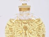 a glass bottle with a gold design on it