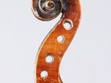 a close up of a violin neck with a fiddle in the background