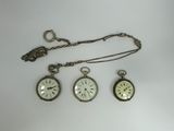 three different types of pocket watches on a white surface