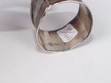 a close up of a silver bracelet with a tag on it