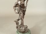 statue d'une femme tenant un panier de fleurs, posée sur un socle en marbre