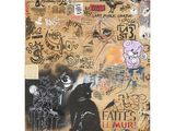 un chat assis sur un mur couvert de graffitis