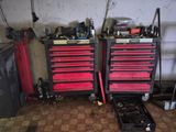 two red tool boxes and a yellow surfboard in a garage