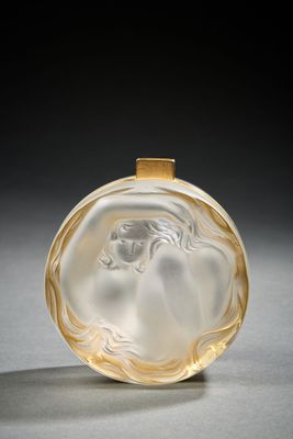 an oval glass snuff bottle with a woman ' s head in the center