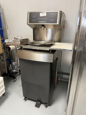 une machine qui se trouve dans une pièce, à côté d'une étagère