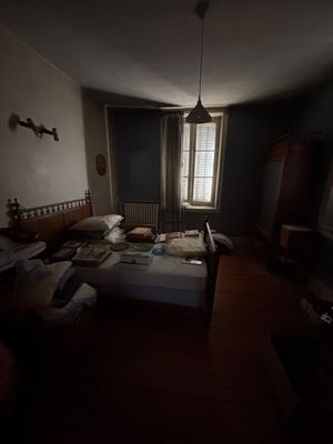a bed in a dark room next to a window
