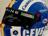 casque dédicacé d'un pilote de course exposé sur un fond blanc