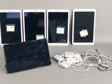 Trois iPad, une tablette et des écouteurs sont posés sur une table