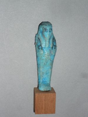 statue d'une femme tenant un bébé sur un socle en bois