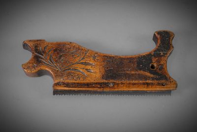 an old wooden comb with a design on it on a gray surface