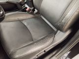 the interior of a car with a black leather seat and steering wheel