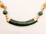 green and gold necklace with a horn shaped horn on a gold chain