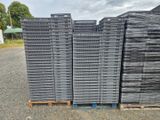 un tas de barres d'acier empilées sur des palettes dans un parking