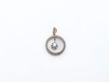 un pendentif en forme de cercle en or blanc et diamants sur fond blanc