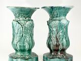 deux vases verts posés l'un à côté de l'autre sur une surface blanche