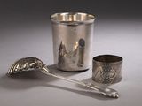 a silver cup and spoon sitting next to each other on a table