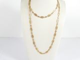 un gros plan sur un mannequin portant un collier à chaîne en or