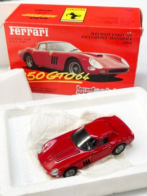 une petite voiture rouge dans une boîte posée sur une table