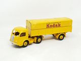 a yellow toy truck with a yellow trailer on a white surface