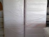 two mattresses that are stacked up in a room
