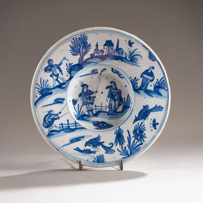 a blue and white plate with a picture of people on it